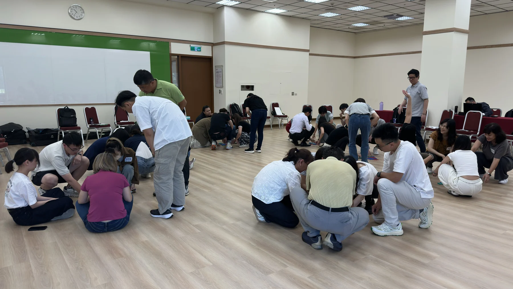 在室內課程空間，參與者分成數組，圍坐地板進行共同任務。